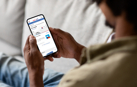 Man using the Exxon Mobil Rewards+ app on a smartphone