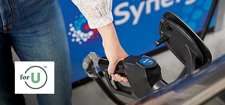 Woman filling car with gas at ExxonMobil gas station, using for U rewards