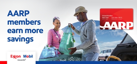 AARP members earn more savings. Man in hat giving green bag to woman in pink shirt